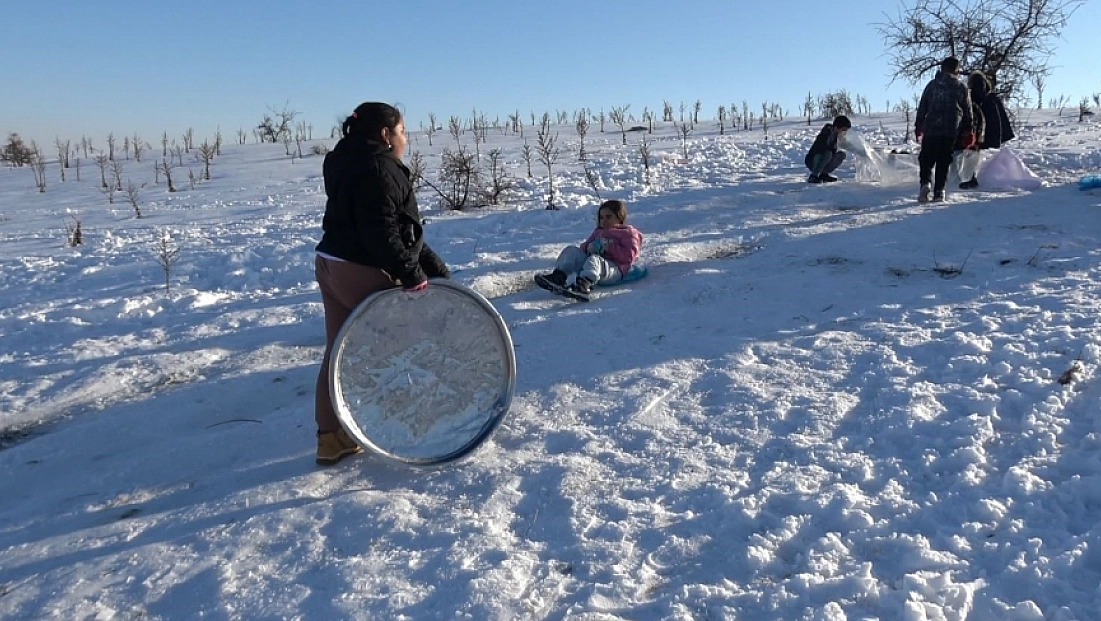 Çocuklar tepsi, poşet ve leğenlerle kayarak eğlendi