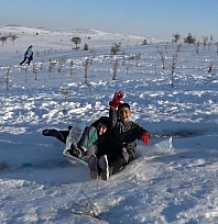Çocuklar tepsi, poşet ve leğenlerle kayarak eğlendi