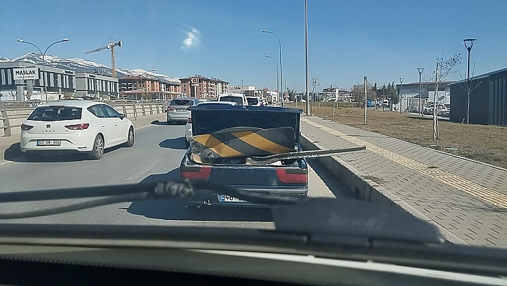 Karayolu işaret levhasını otomobil ile taşıdı